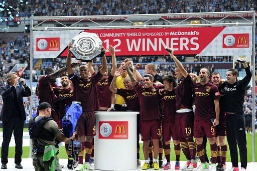 Manchester City's Vincent Kompany lifts their FA Community Shield trophy